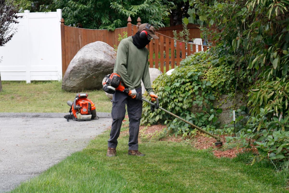 Trimming hedges along a fence line